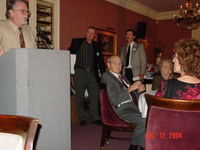 Terry Meyer helping Byron Personett pass out his gifts to the crew, a wooden 
box with a Navy knife and lighter.
